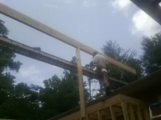Carpenter setting a ridge beam over a new addition frame — Ice Dam Removal by Roofing Brothers in Okauchee