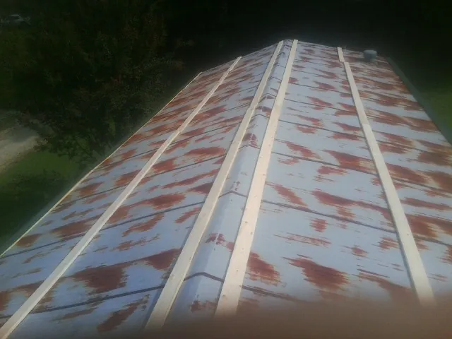 Rusted metal roof panels with new wood purlins before replacement — Storm Damage Roof Repair in Okauchee by Roofing Brothers