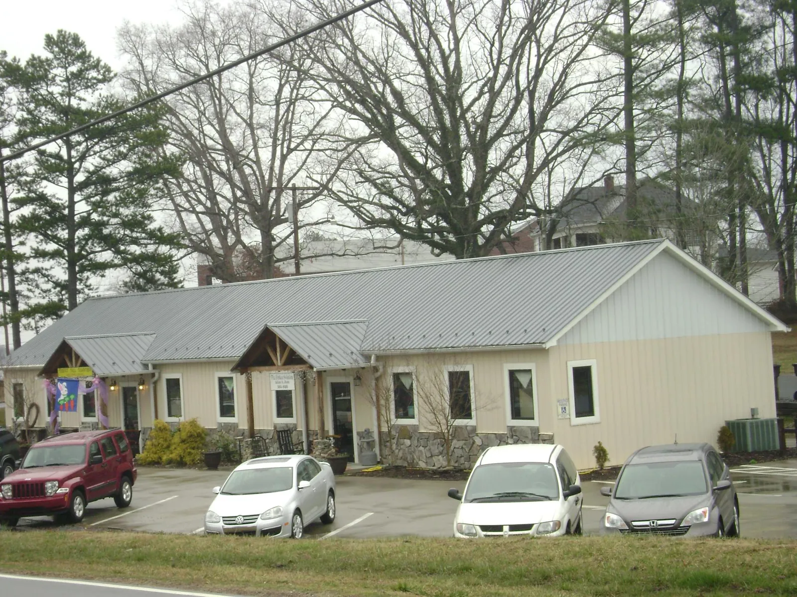 Gray metal roof with timber entry brackets on a small commercial building in Okauchee