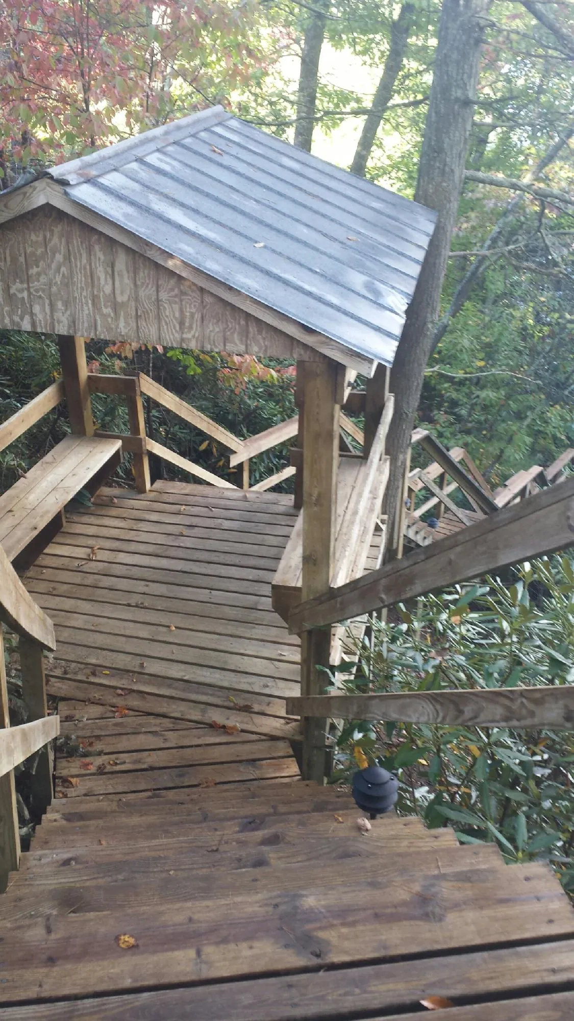 Metal roofed shelter over wooden steps on a wooded walkway — Skylight Repair & Installation work by our crew in Okauchee
