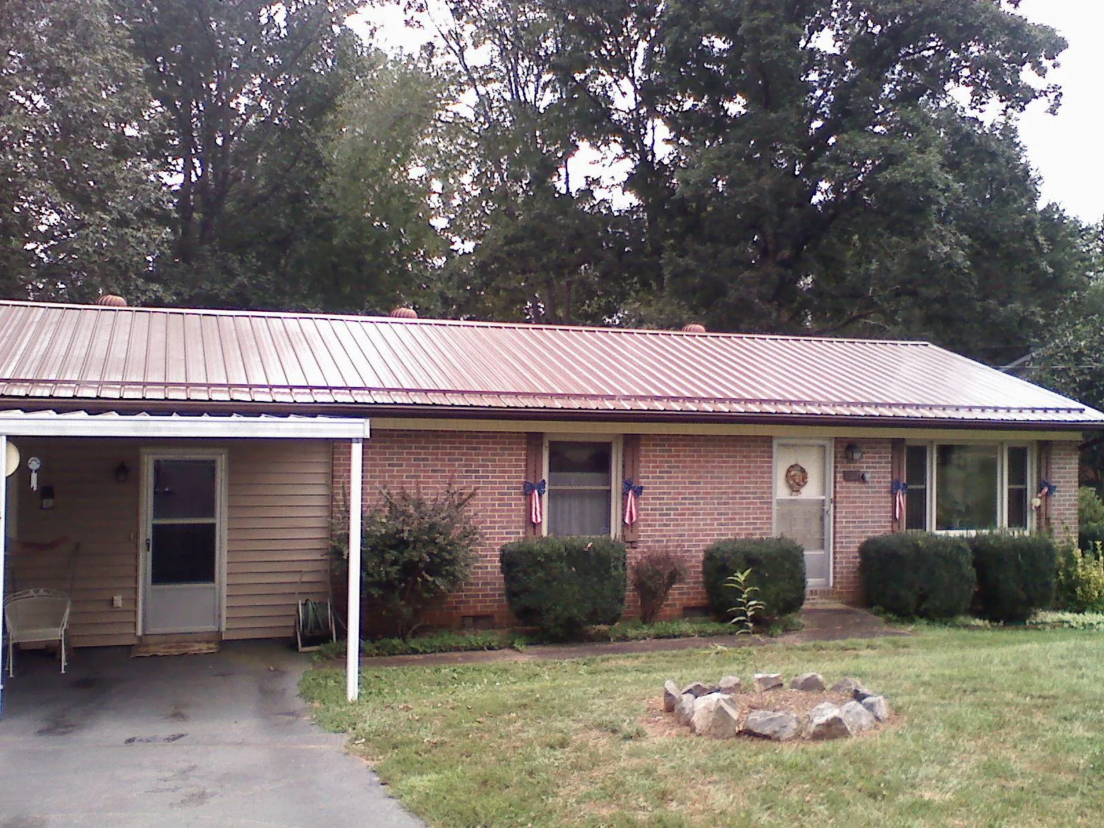 Bronze metal roof and carport on a brick ranch home — Roof Repair work by our crew in Okauchee